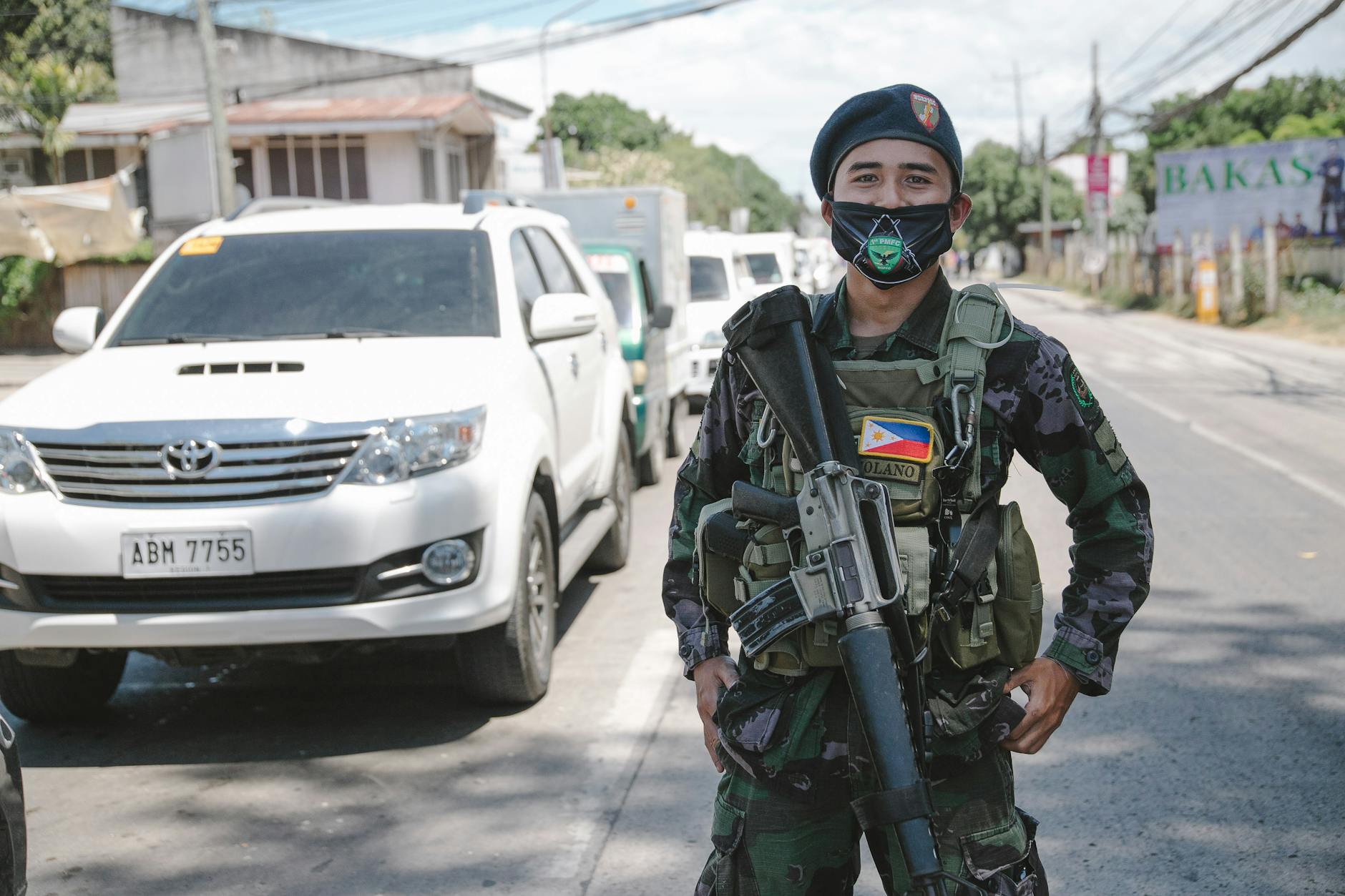 military man with weapon standing on street